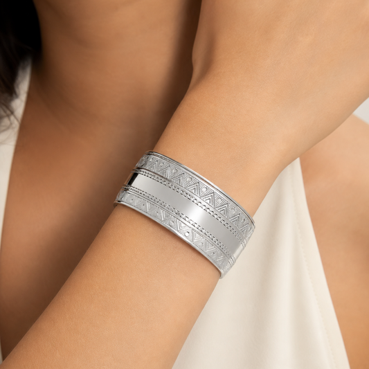 Silver bracelet on a person's wrist with a neutral background